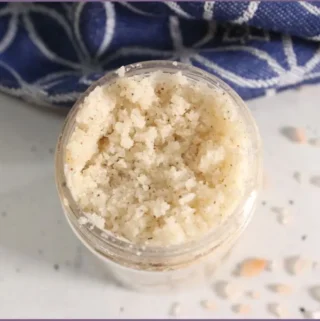 Glass bottle filled with DIY exfoliating foot scrub with essential oils