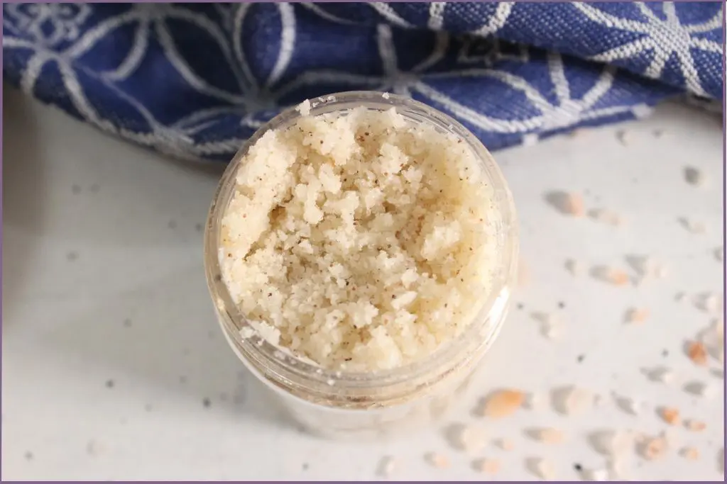Glass bottle filled with DIY exfoliating foot scrub with essential oils