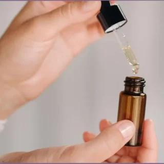 lady using dropper for essential oils - How many drops in 10 ml essential oil