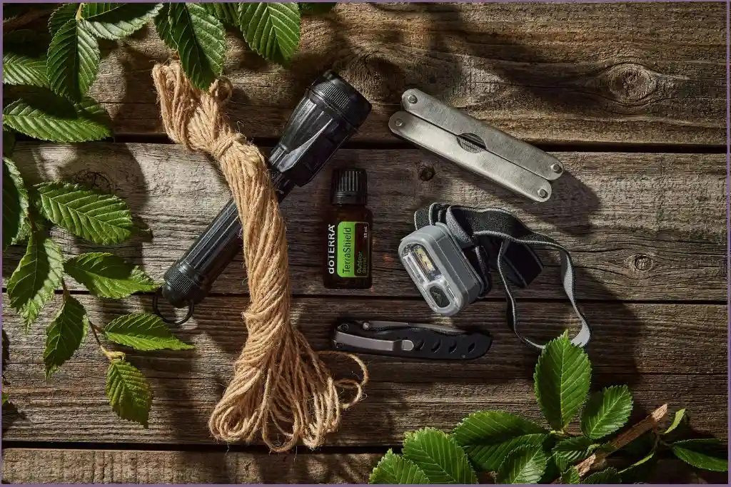 essential oil bottle, penknife, and torch on wooden table outdoors