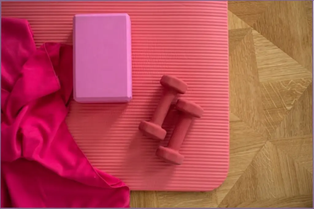 pink yoga mat and pink dumbbells - how to freshen yoga mat with tea tree essential oil