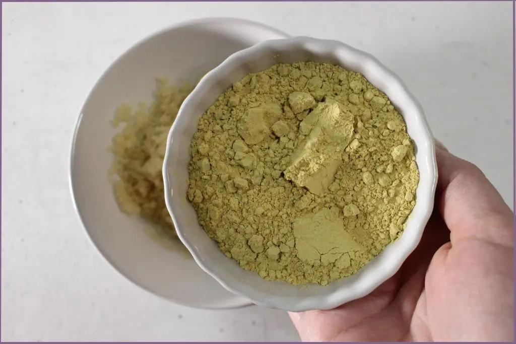 Adding pumpkin powder to a bowl with sugar to make pumpkin spice sugar scrub