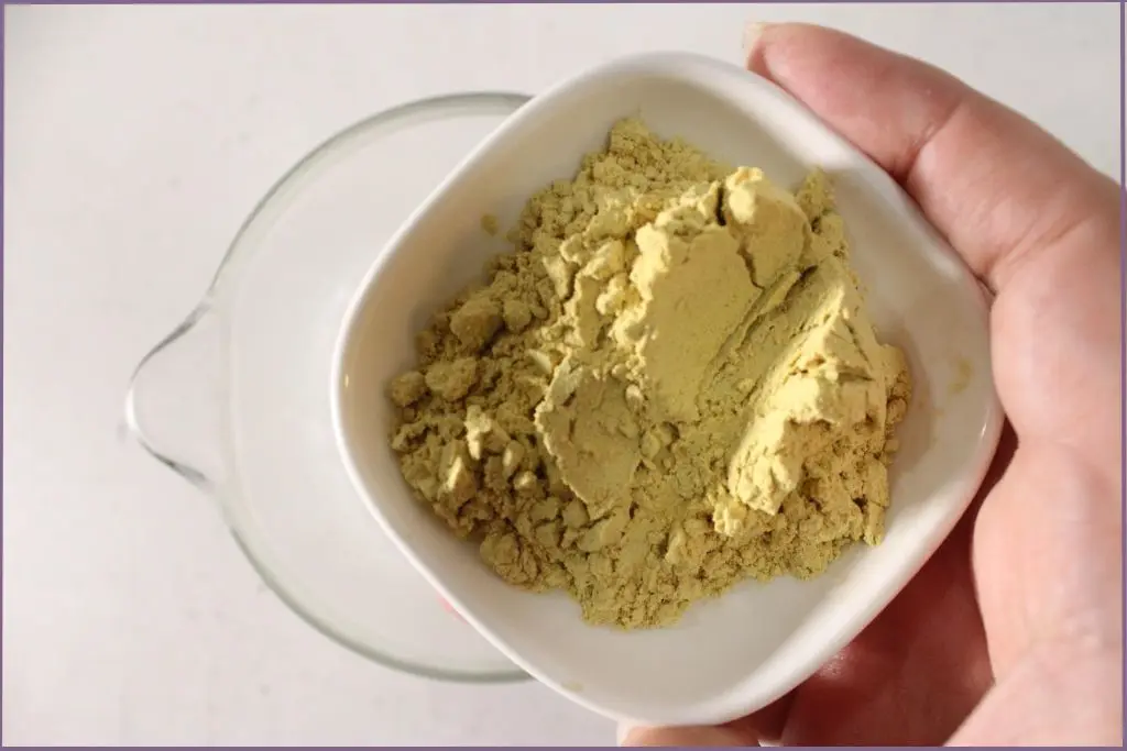 person adding pumpkin powder to the melted soap base to make pumpkin spice soap