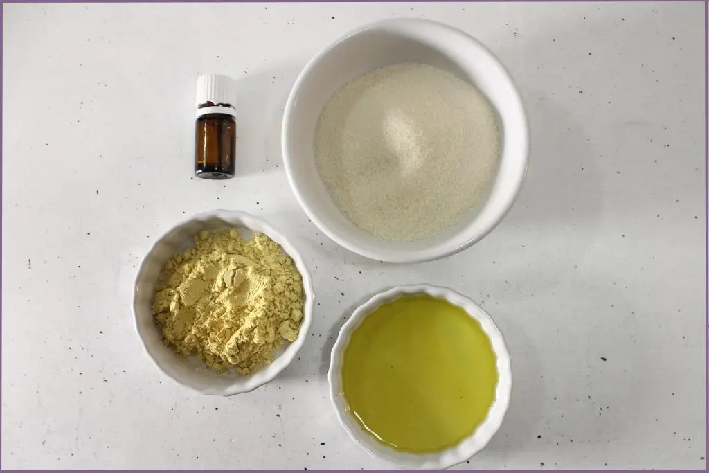 3 white bowls with sugar, pumpkin powder and carrier oil + essential oil botte - Ingredients for pumpkin spice body scrub recipe