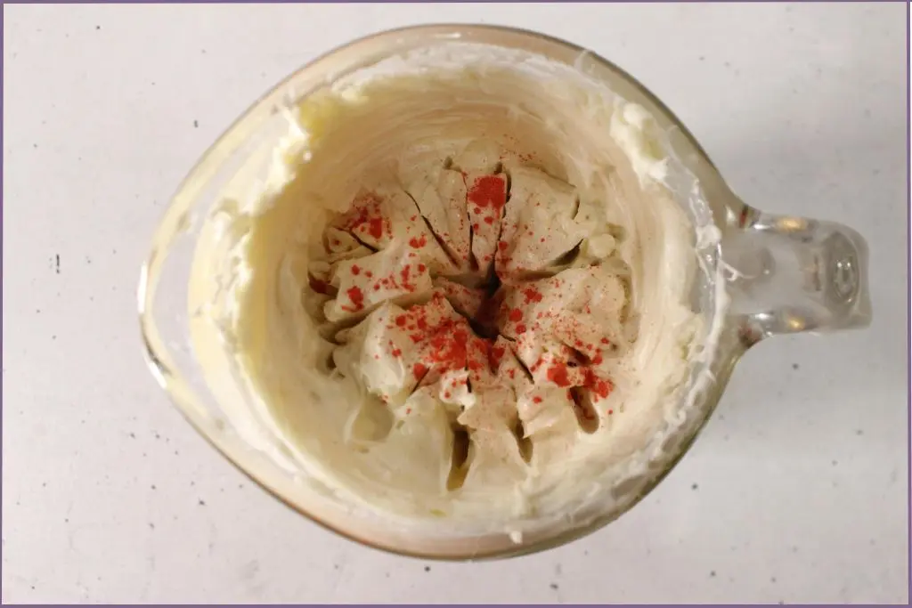 top view of measuring jar with orange mica powder to color homemade pumpkin spice body butter