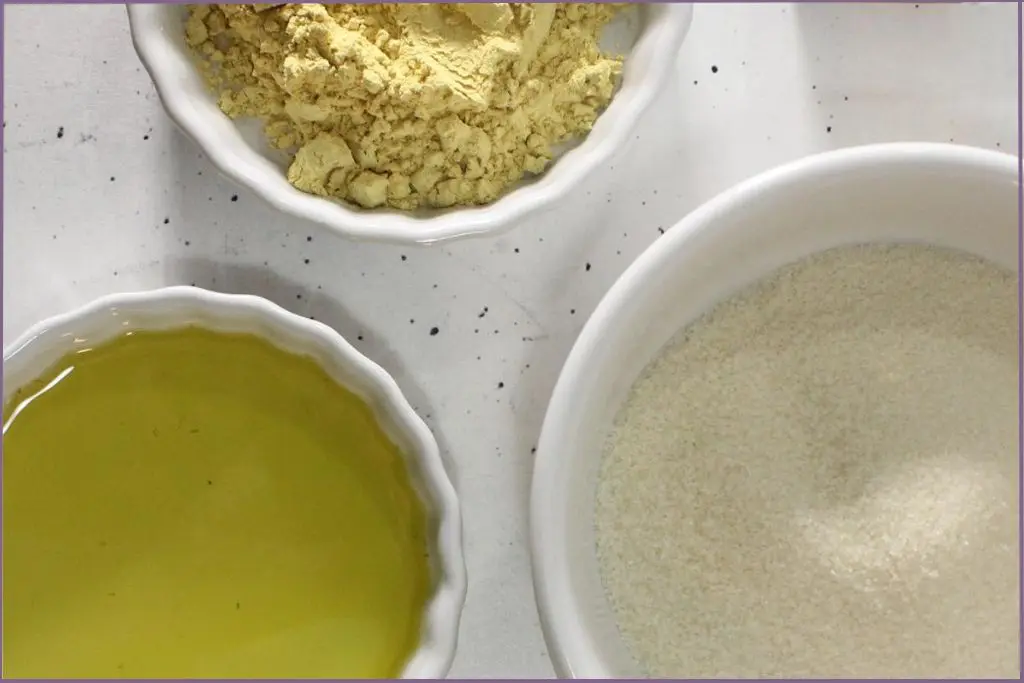 bowls with pumpkin powder, white sugar, and carrier oil for adjusting the consistency of homemade pumpkin spice sugar scrub