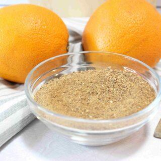 2 oranges and a bowl of orange peel powder