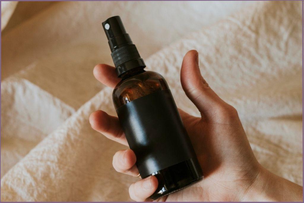 Hand holding a bottle of fall scented room spray