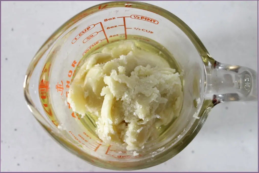 Top view of shea butter and carrier oil in measuring jar to make homemade pumpkin spice whipped body butter