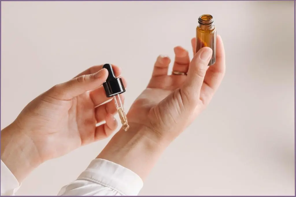 lady using a dropper to apply essential oil to inside of the wrist, which is a classic pulse point for essential oils
