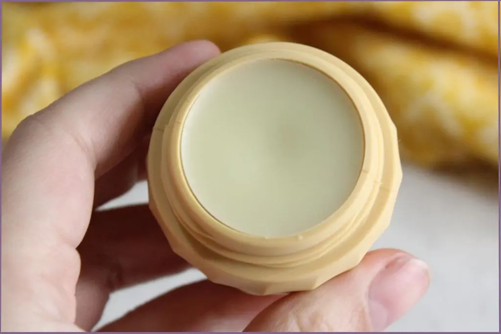 person holding small balm container filled with DIY cuticle balm with shea butter- tips for best results
