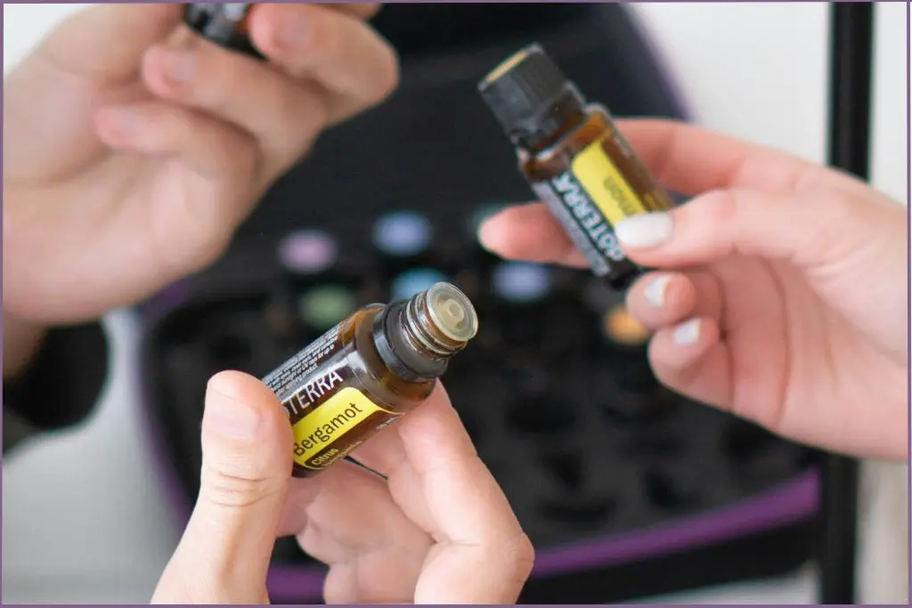 person holding a bottle of bergamot essential oil - tips for choosing the best essential oil for meditation