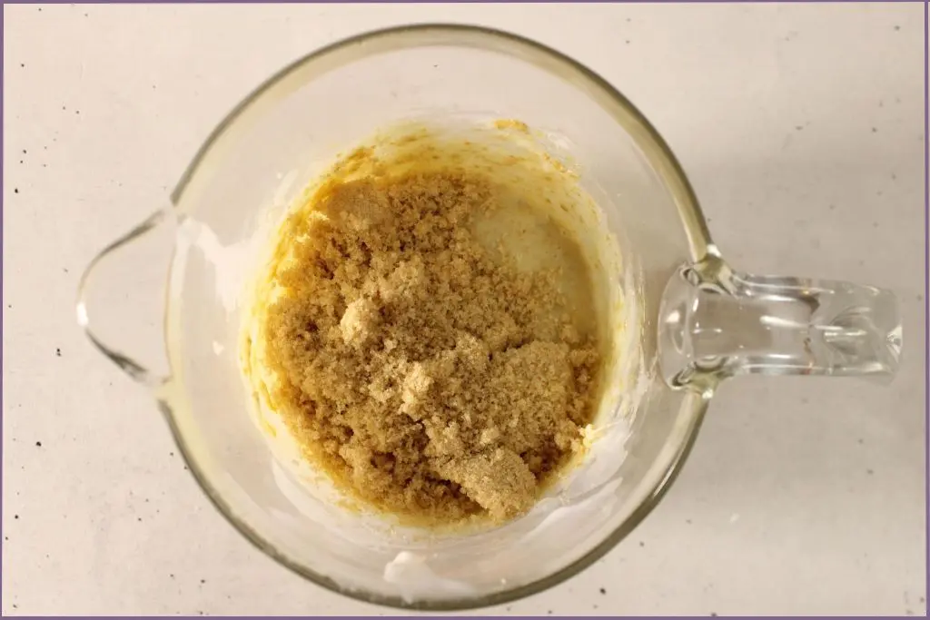 Measuring jar with brown sugar added to melted pumpkin spice sugar scrub base