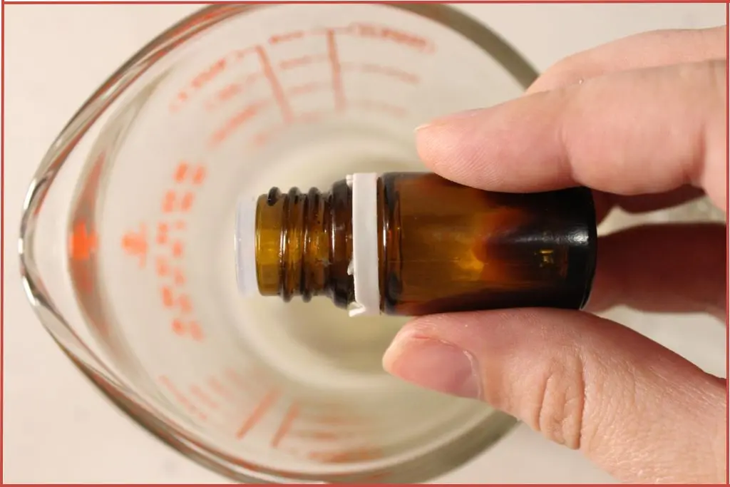 Add essential oil into glass jar with melted lip balm