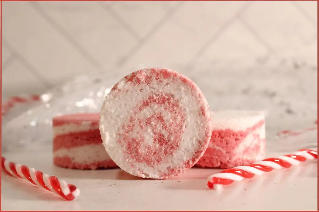 Three peppermint-inspired bath bombs, one showing a red-and-white swirl pattern, surrounded by candy canes with customization ideas