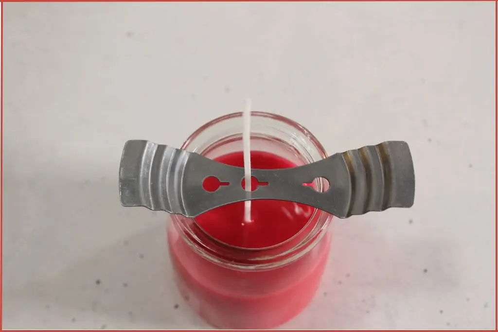 Overhead view of homemade candy cane candle in a jar set aside to cool and harden