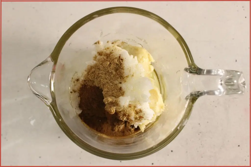 Glass measuring jar with ingredients to make gingerbread body butter