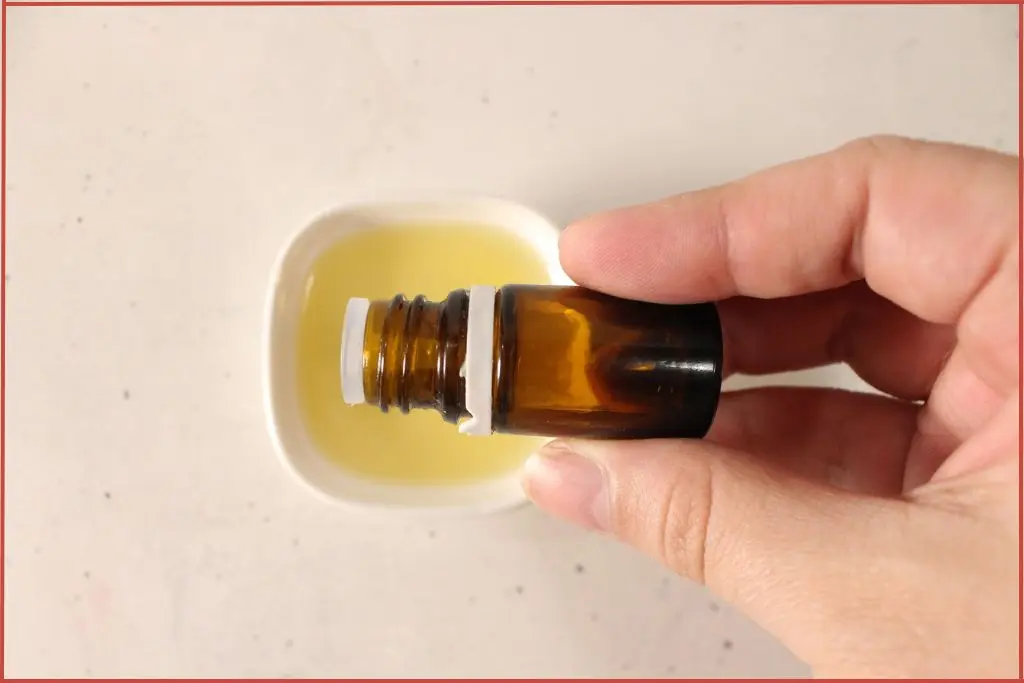 Blending candy cane essential oil blend with carrier oil to make Christmas lip scrub