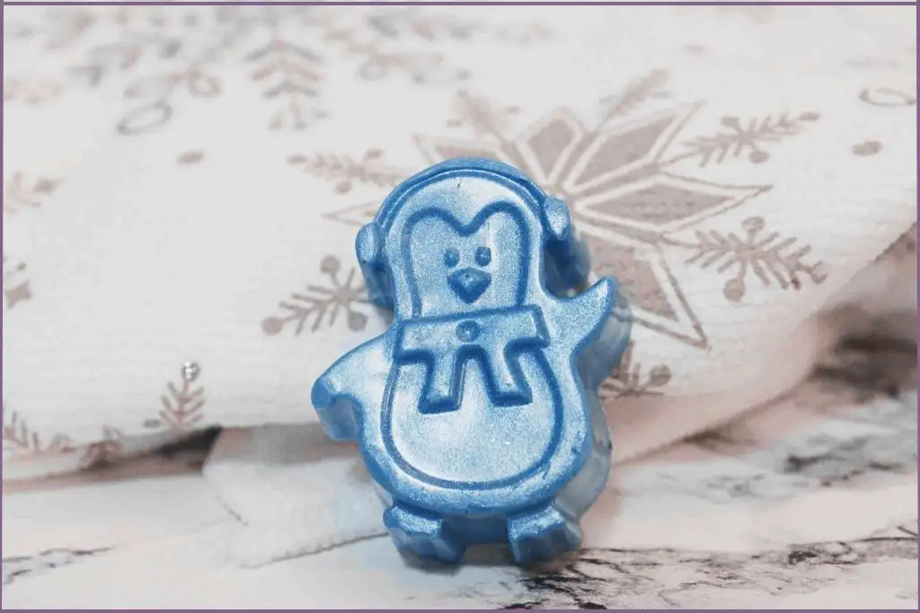 One blue homemade Christmas penguin on a festive tablecloth