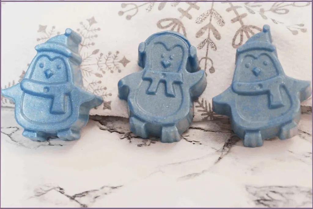 3 blue homemade Christmas penguins on a festive tablecloth