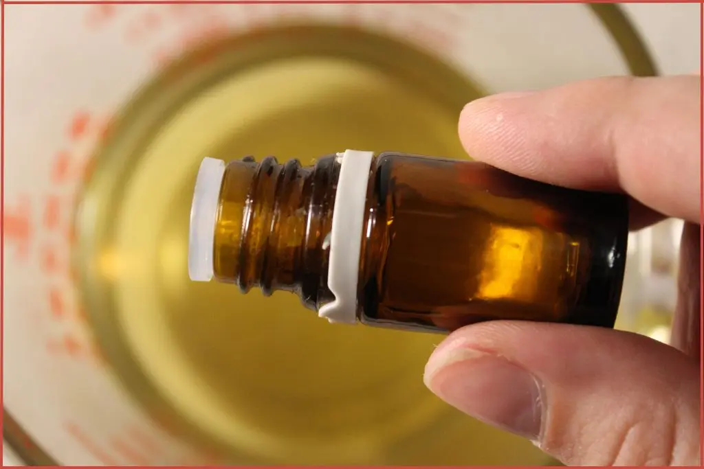 Adding essential oil from bottle into melted soy wax