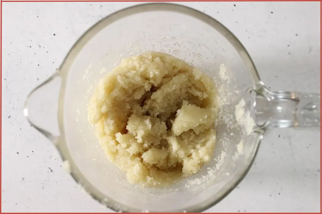 Sugar and melted shea butter and beeswax in a glass measuring jar to make snowflake sugar scrub bars
