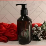 foaming soap dispenser bottle, dark colored, with red festive towel and Christmas decor