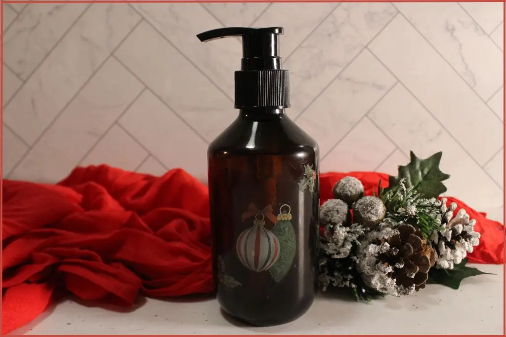 foaming soap dispenser bottle, dark colored, with red festive towel and Christmas decor
