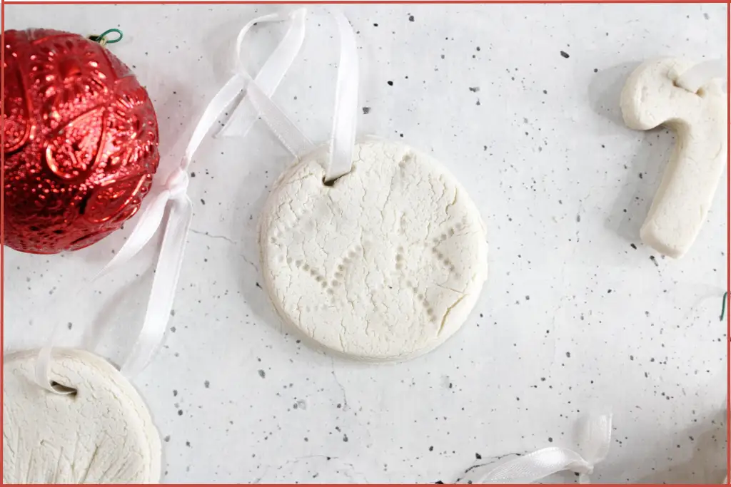 Completed Christmas diffuser ornaments with ribbons for hanging and a red bauble on the side