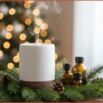 Essential oil diffuser and 3 bottles nestled among Christmas pine needles diffusing blends for peace, focus, and joy