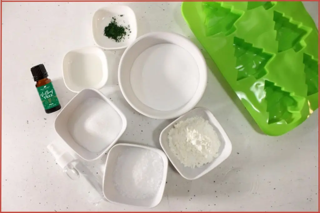 Ingredients required to make Christmas tree bath bombs with a Christmas tree mold and bottle of Plant Therapy blend