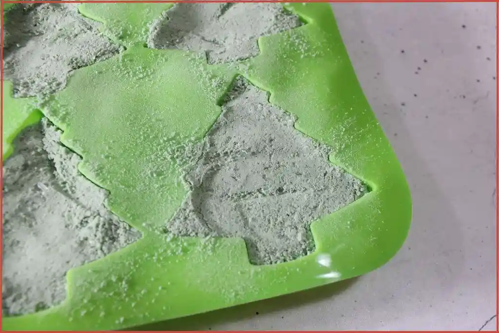 Close-up of a green Christmas tree shaped mold filled with green bath bomb mixture