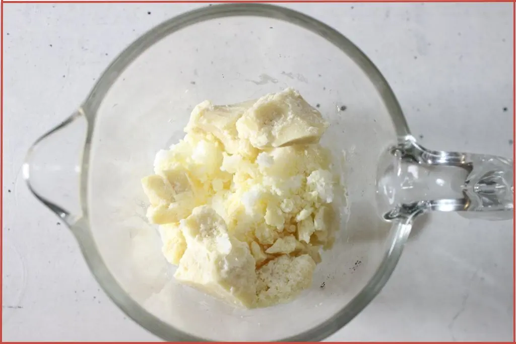 Cocoa butter and tallow in a glass measuring jar