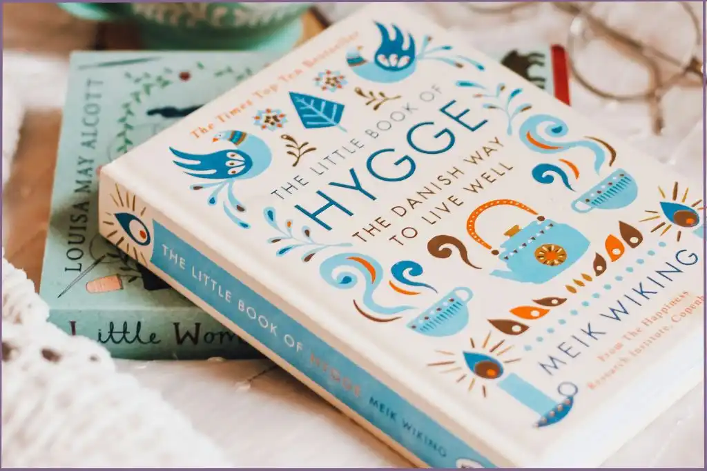 'The Little Book of Hygge' on a cozy surface, warm lifestyle inspiration for hygge diffuser blends.